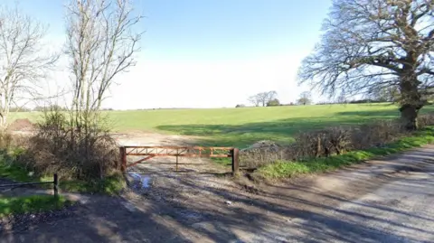 A field with a small gate blocking the entrance.