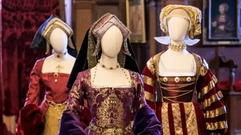 Hever Castle Three ornate Tudor dresses are displayed on manikins with white, empty faces.