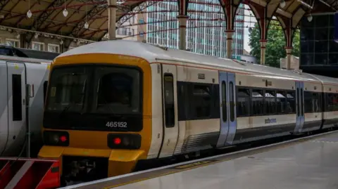 Getty Images A white Southeastern train with blue doors and a yellow front parked at London Victoria station.