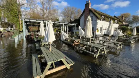 Flooded benches and seats at a pub in the village of Burghfield near Reading in Berkshire