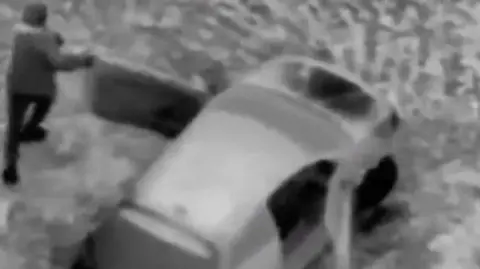 South Yorkshire Police Still from police helicopter video of men leaving the car that had been followed by South Yorkshire Police. Black and white thermal image of a man (left) and a car (right).