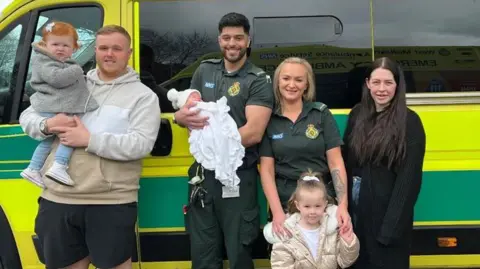 Ameii-Lee Lockley, Robert Lockley and their children with paramedics Anna Lisowska and Marius Faraji