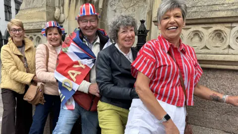 Five relatives smile and stand in a conga line