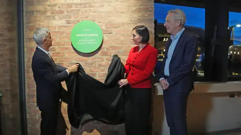 PA Media Mayor of London Sadiq Khan (left) unveils a plaque at the opening of Sadler's Wells East theatre.