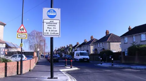 A general view picture of Honeysuckle Road in Southampton, a residential area, and a street sign showing the restrictions.