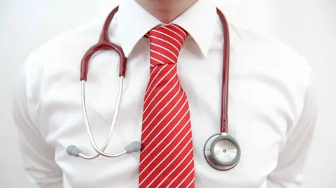 PA A doctor's torso close up with a red tie and stethoscope 