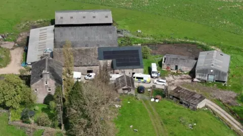Police vehicles on a farm viewed from the sky