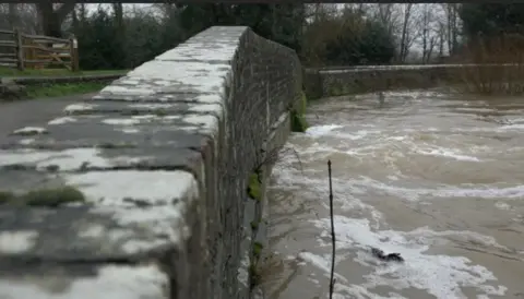 Jody Sabral Water levels really high virtually reaching the top of a stone bridge and Barcombe