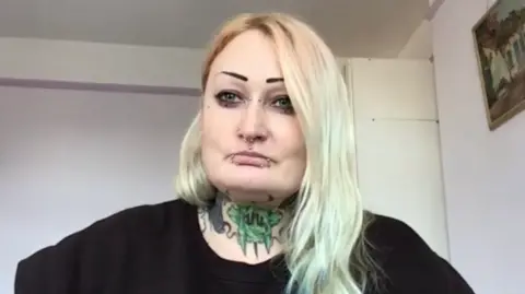 Woman with blonde hair and colourful tattoos on her neck
