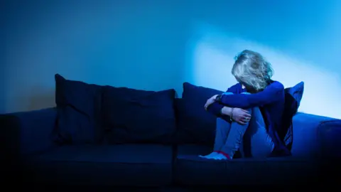 PA Media Lady sat on a sofa