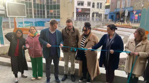 LDRS Adam Dance stands in the centre of a line of seven people who cut the ribbon at the unveiling of the new amphitheatre in Yeovil