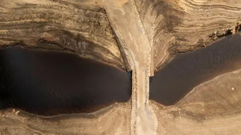 Dry cracked earth at Baitings Reservoir in Ripponden, West Yorkshire