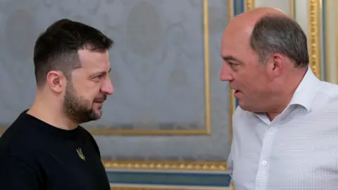 Reuters Ukrainian president Volodymyr Zelensky, left, stands talking to former UK defence secretary Ben Wallace in a meeting in 2022