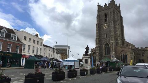 Market Hill in Sudbury, with the church and market stalls in view