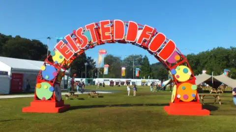 A large red semi circle sign with the word 'Eisteddfod' in colourful block letters