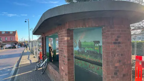 Jack Maclean/BBC The Sheringham bus shelter which has a painted mural of a train inside of it.