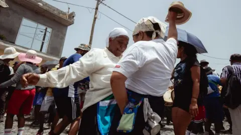  Queila Fernandes/AFP Two women dance during the pilgrimage in Porto Novo
