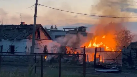 Reuters Sebuah bangunan terbakar di kota Sudzha setelah pasukan Ukraina memasuki wilayah Kursk di Rusia pada 7 Agustus.