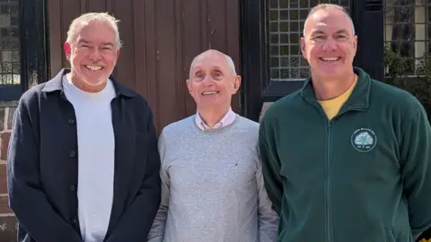 A view of Martin Townley, Paul Clegg and Tony Ashcroft standing in front of Willaston Memorial Hall