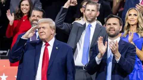 EPA Trump salutes at the republican convention with sons Don Jr and Eric in the row behind him