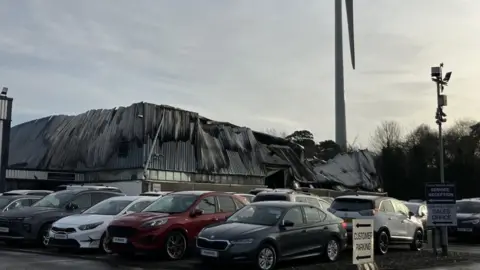 Cars on the forecourt in front of the building at Fusco Vehicle Sales in Bangor where the roof has melted.