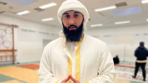 Bilal Raja, a young man with a long dark beard, looking at the camera.