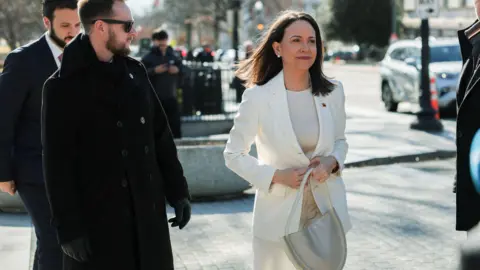 Reuters Machado in a white suit walking to the White House to meet Trump