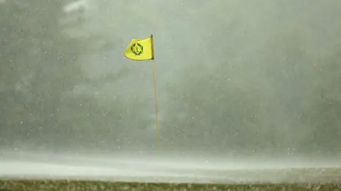 A flag billowing in the wind in heavy rain
