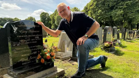 Russell Lowbridge pictured next to his grandfather's grave at Sutton Cemetery