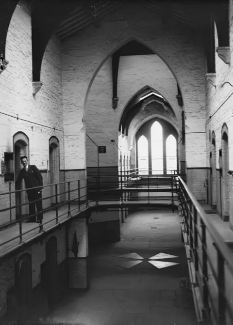 Getty Images Inside the prison, a man looms in the corridor on the left