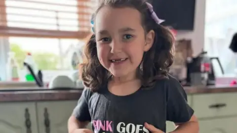 Handout A smiling Bebe King shows off her t-shirt, which has a logo from the Wicked musical, and the caption "pink goes with green"