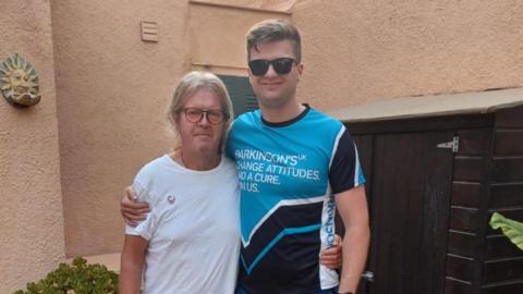 Luke Bakewell is pictured in a Parkinsons UK t-shirt next to his dad, Chris