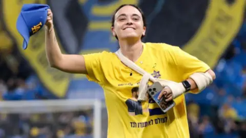 Ziv Koren British-Israeli ex-hostage Emily Damari wears the yellow and blue colours of Maccabi Tel Aviv Football Club at a match 