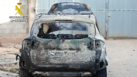 A police photograph of a torched car.