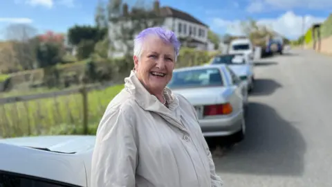 St Peter Port constable Jenny Tasker with two of the abandoned cars behind her
