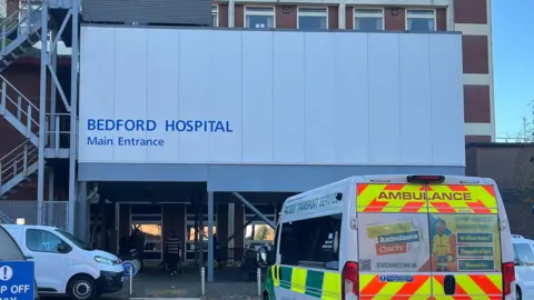 Tony Fisher/BBC The front of Bedford Hospital's main entrance with an ambulance parked outside.