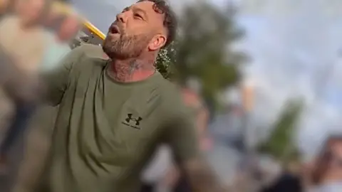 A screen grab of police body cam footage showing a man taking part in a protest.