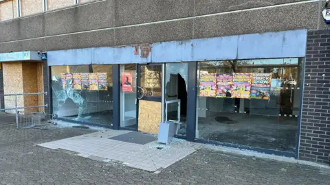 Richard Stangward Vandalised shop unit with broken windows 