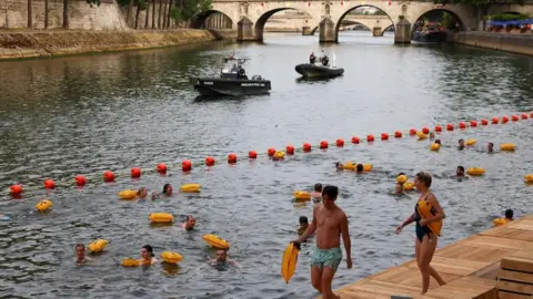 People swim in the River Seine at the Bras Marie site