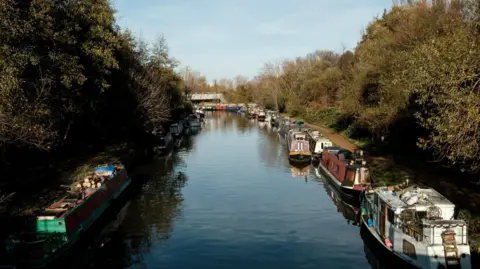 A file image of narrow boats moored along the banks of the River Lea in north-east London.