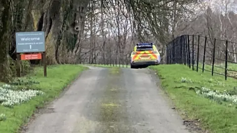 A police car parked on a grass verge 