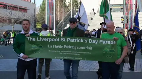 Marchers display their banner down Hope Street with the Metropolitan Cathedral in the background