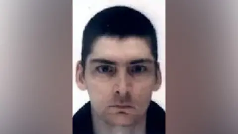 A man with cropped, dark hair looking directly into the camera.