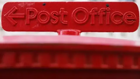 An image of the Post Office logo on top of a postbox