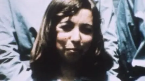 PA Media An old colour photograph of a young woman with long brown hair.