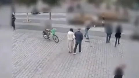 Dave Mathias A CCTV image shows a Lime bike approaching a woman and a man