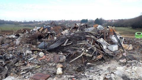 A pile of burned waste at the site