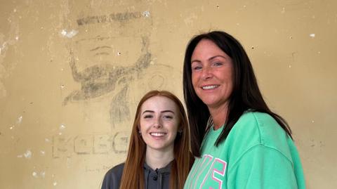 Chloe and Lisa Young in front of the Robocop wall drawing