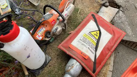BBC/ Seb Cheer Repair equipment laid near knocked down speed camera.