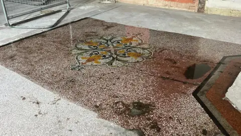 supplied A dirty tiled floor with a mosaic pattern
